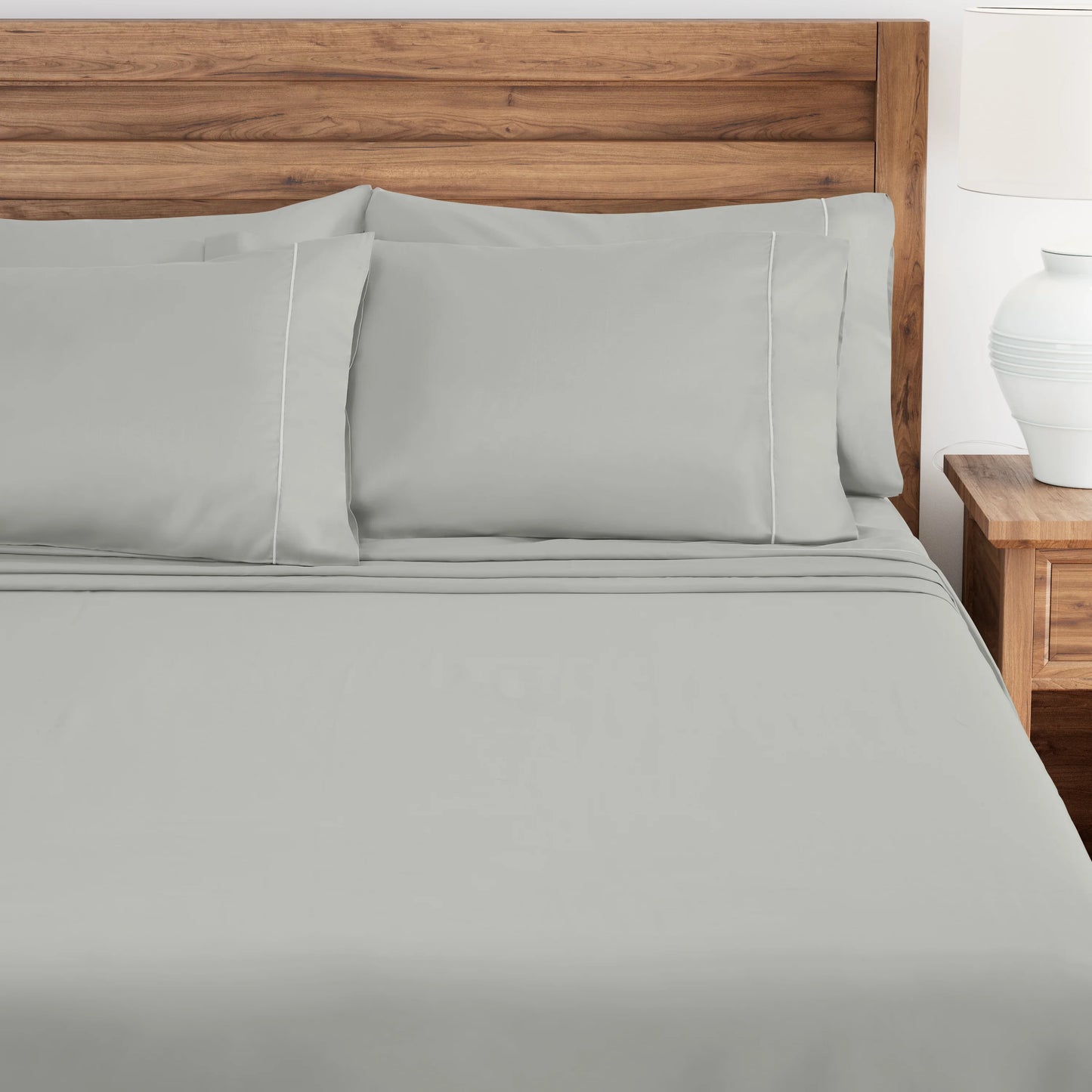 Oystershell bedding set on a bed with a wooden headboard and nightstand.